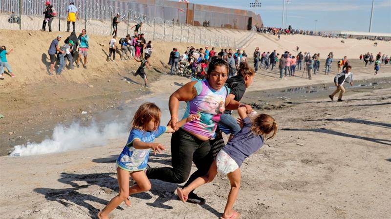 Maria Meza, a migrant woman from Honduras, runs away from tear gas with her five-year-old twin daughters Saira and Cheili at the US-Mexico border on November 25, 2018 [File: Reuters/Kim Kyung-Hoon]