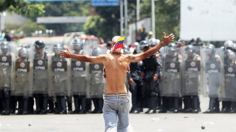 Opposition protesters face the Venezuelan police at the Simon Bolivar international bridge in Cucuta, Colombia [Ernesto Guzman Jr/ EPA]