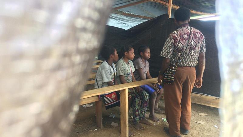 Children sit on benches at a temporary school built for those feeling unrest in Nduga [Febriana Firdaus/Al Jazeera]