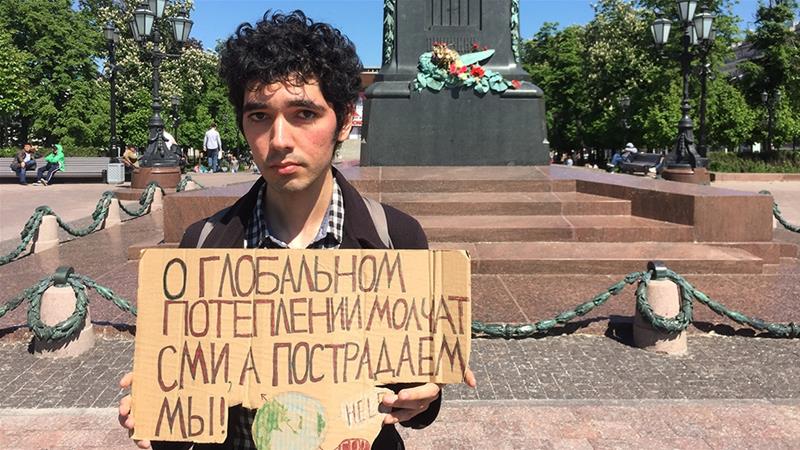Arshak Makichyan sostiene un letrero que dice 'Nuestros medios de comunicación no dicen nada sobre el calentamiento global, pero somos los que sufriremos' [Jonathan Brown / Al Jazeera]