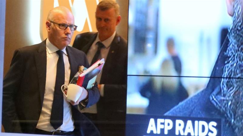 John Lyons, the ABC executive editor, followed by a police officer as they leave the broadcaster's Sydney offices [David Gray/EPA-EFE]