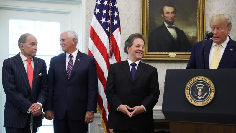 White House chief economic adviser Larry Kudlow and US Vice President Mike Pence stand by as President Donald Trump speaks during a presentation of the Presidential Medal of Freedom to economist Arthur Laffer, a theorist best known for supporting supply-side economics [Jonathan Ernst/Reuters]