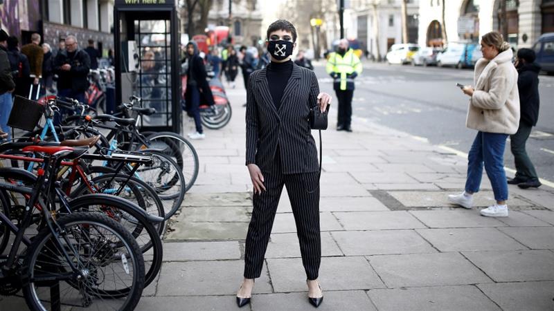 A fashion show attendee wears a face mask outside a venue at London Fashion Week in London, United Kingdom, where organisers expect a subdued turnout [Henry Nicholls/Reuters]