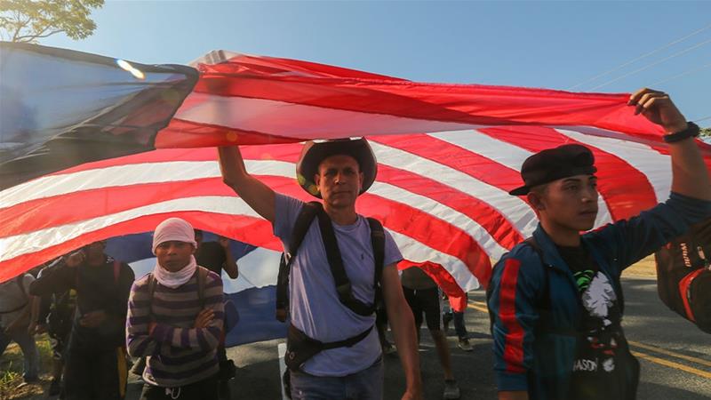 Central American migrants carrying a homemade US flag walking in Ciudad Hidalgo, Mexico [Marco Ugarte/AP Photo] 