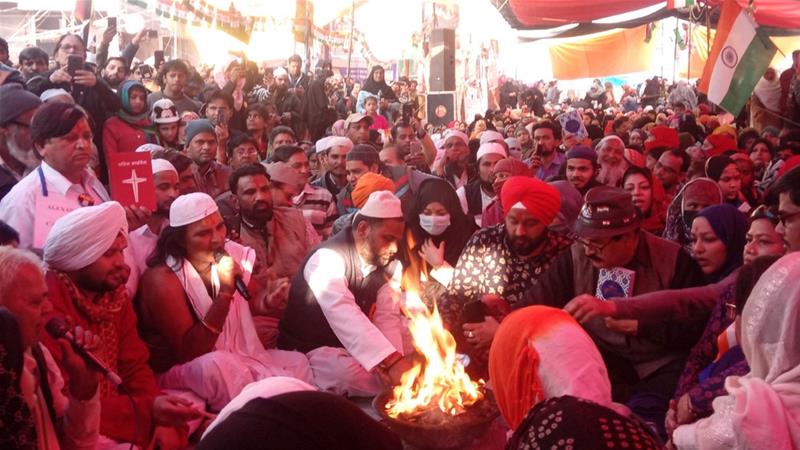 A Hindu priest lights the holy fire at Shaheen Bagh as people from other faiths participate in prayers [Sumaira Rizvi/Al Jazeera]