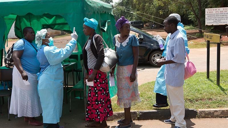 Health workers screen people visiting a public hospital in Harare, Zimbabwe [Tsvangirayi Mukwazhi/AP]