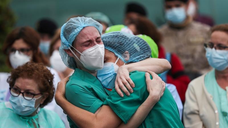 Health workers in Spain pay tribute to a colleague who died of COVID-19. The coronavirus has now been confirmed in some 1.97 million people around the world [Susana Vera/Reuters]
