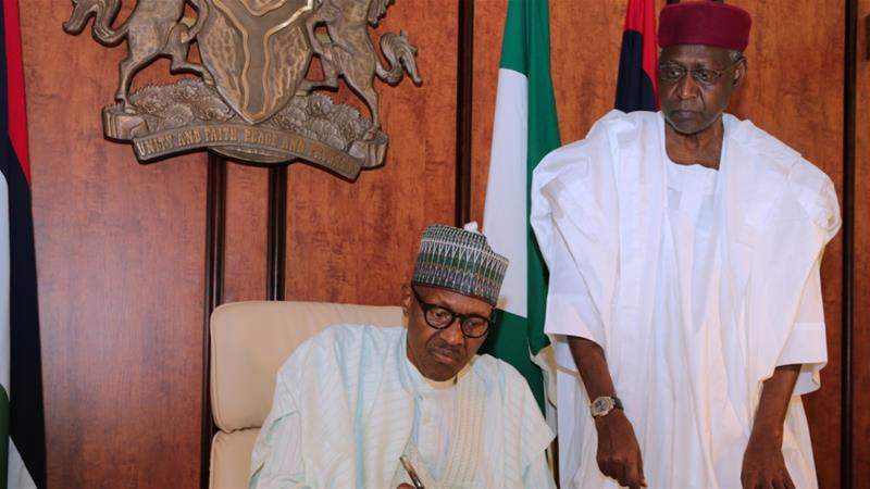 A handout image made available by the Nigerian State House shows the Nigerian president sitting beside his Chief of Staff Abba Kyari [File: Sunday Aghaeze/AFP]
