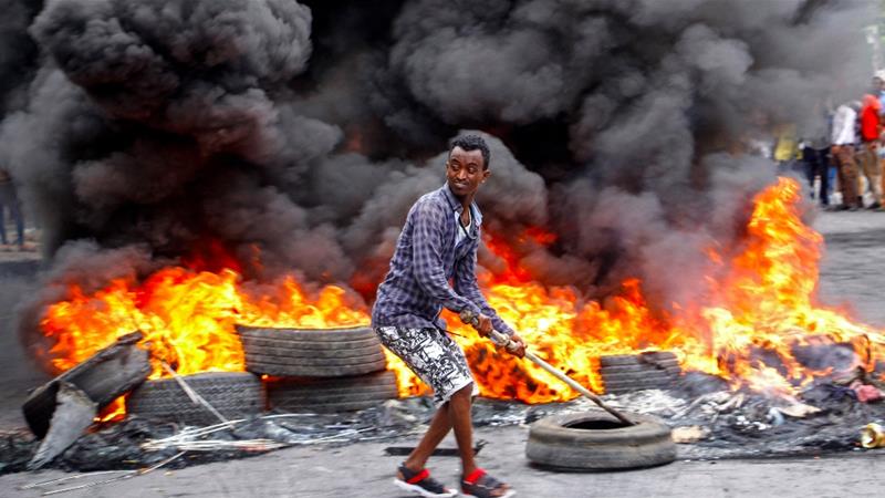 A man protests in Mogadishu against the killing of at least one civilian during the overnight curfew [Farah Abdi Warsameh/AP]