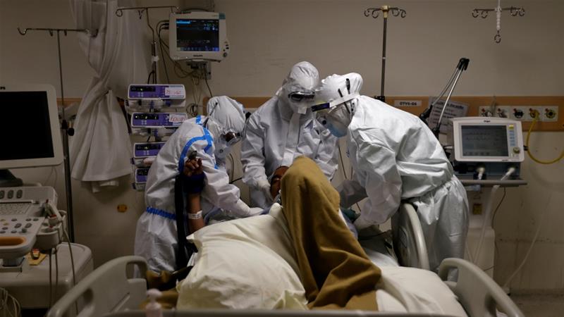 Medical workers wearing personal protective equipment take care of a patient suffering from the coronavirus disease at a hospital in New Delhi [Danish Siddiqui/Reuters]