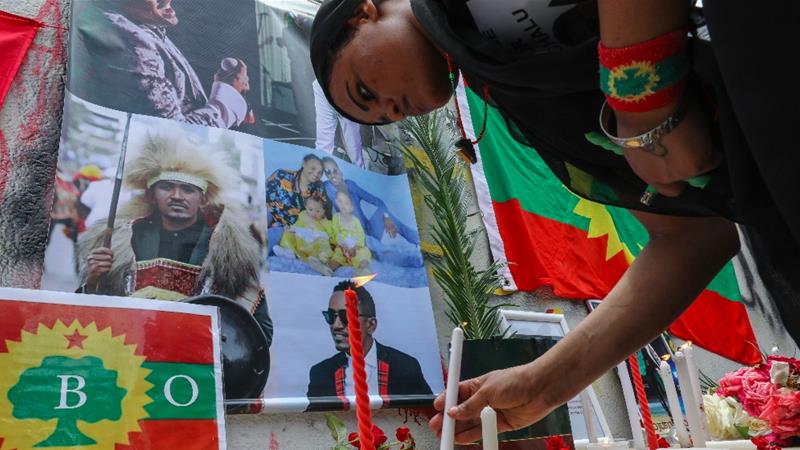 A member of the Oromo Ethiopian community in Beirut, Lebanon lights a candle to protest the death of musician and activist Hachalu Hundessa [Anwar Amro/AFP]