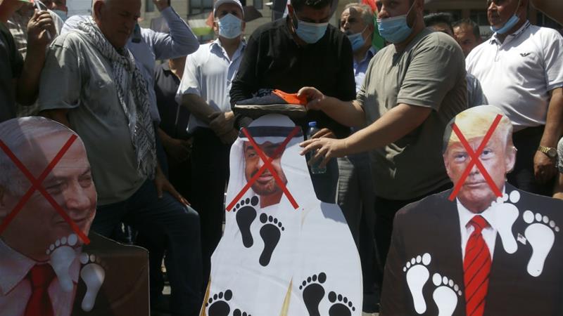 Palestinians place shoes on pictures of American, Israeli and Emirati leaders during a protest against the UAE's deal with Israel, in Nablus, West Bank, Aug 14, 2020 [AP Photo/Majdi Mohammed]