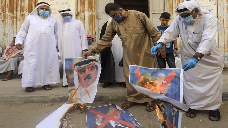 Palestinians burn images of the Bahraini king, US president and the Israeli prime minister during a protest in Deir al-Balah in central Gaza Strip on Saturday [Mahmud Hams/AFP]
