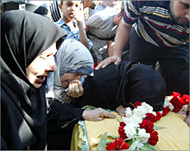 The mother and sisters of fighterweep over his coffin 