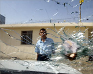 An Iraqi policeman looks into his dead colleagues' car
