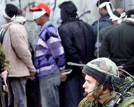 An Israeli soldier watches overPalestinian men detained in Balata