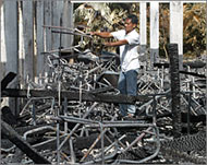 A man rummaging through the debris of a torched school 
