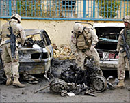 US soldiers inspect the debris of a vehicle in Samarra