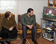 Bassam (R) watches Nasr Allah'sconference with his mother