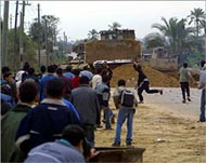 Young Palestinians throw stonesto stop Israelis blocking off camp