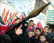 A man holds a RPG launcher near Yasin's house