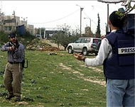 An Israeli settler aims at aPalestinian cameraman in Hebron