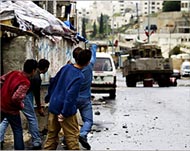 Local boys prepare to stone anIsraeli tank in Nablus