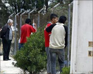 Turkish Cypriots look through a fence to the Greek south