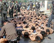 Some of the demonstrators lie on a pavement under arrest
