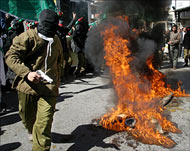 Hamas members burn effigies during a rally in Ram Allah on Friday
