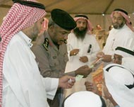 A Saudi security officer explains to voters how to register to vote