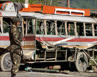 An Indian Army soldier guards the wrecked vehicle in Srinagar