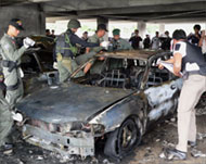 Paramilitary officers inspect carsafter a blast in Narathiwat in June