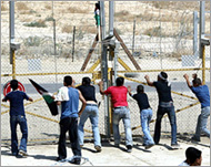 Palestinians and ISM activists tryto bring down West Bank's wall