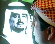 A Saudi man kisses a television showing a picture of King Fahd