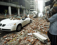 A man videotapes a car crushed by falling debris 