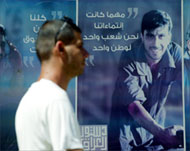 A man passes posters promoting the constitution in Baghdad