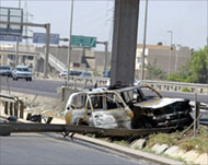 A burned police car is abandoned after clashes on Friday in Baghdad