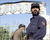 A policeman stands guard outside a polling station in Kandahar