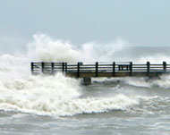 Waves crash over a fishing pier in Galveston, Texas
