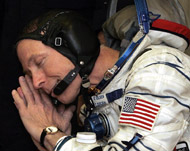 Gregory Olsen gestures during testing of his space suit