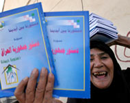 A woman in Baghdad receivesbooklets on the constitution