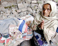 An 80-year old quake survivor amid her collapsed house 