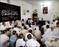 Residents of Dujail watch the trial on television