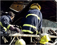 Firefighters removed charred bodies from the bus wreckage 