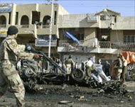 An Iraqi soldier secures the scene of a car bomb in Baghdad 