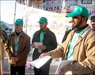Hamas supporters hand out leaflets to voters