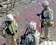 US soldiers inspect the blast site in Baquba that killed 16 people 