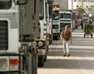 A Palestinian walks past trucks after the Karni crossing opened 