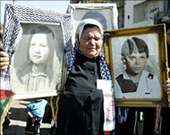 A woman holds pictures of relatives killed in Sabra camp